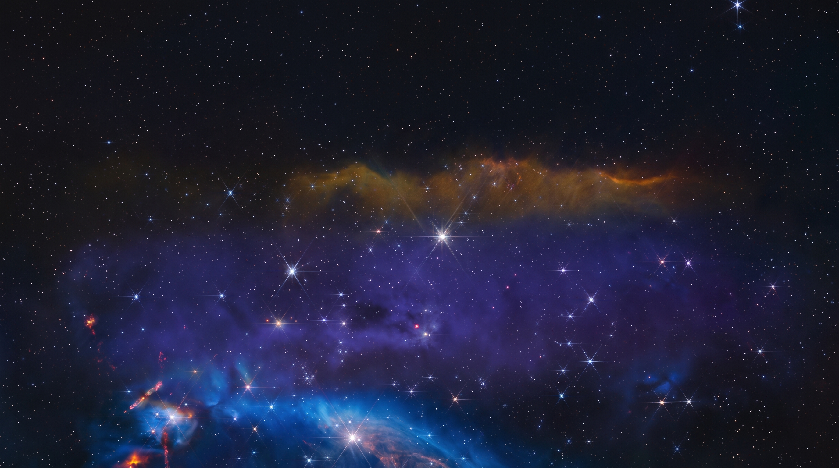 Faint reddish brown dwarf star with a thin dust disk glowing inside a colorful stellar nursery