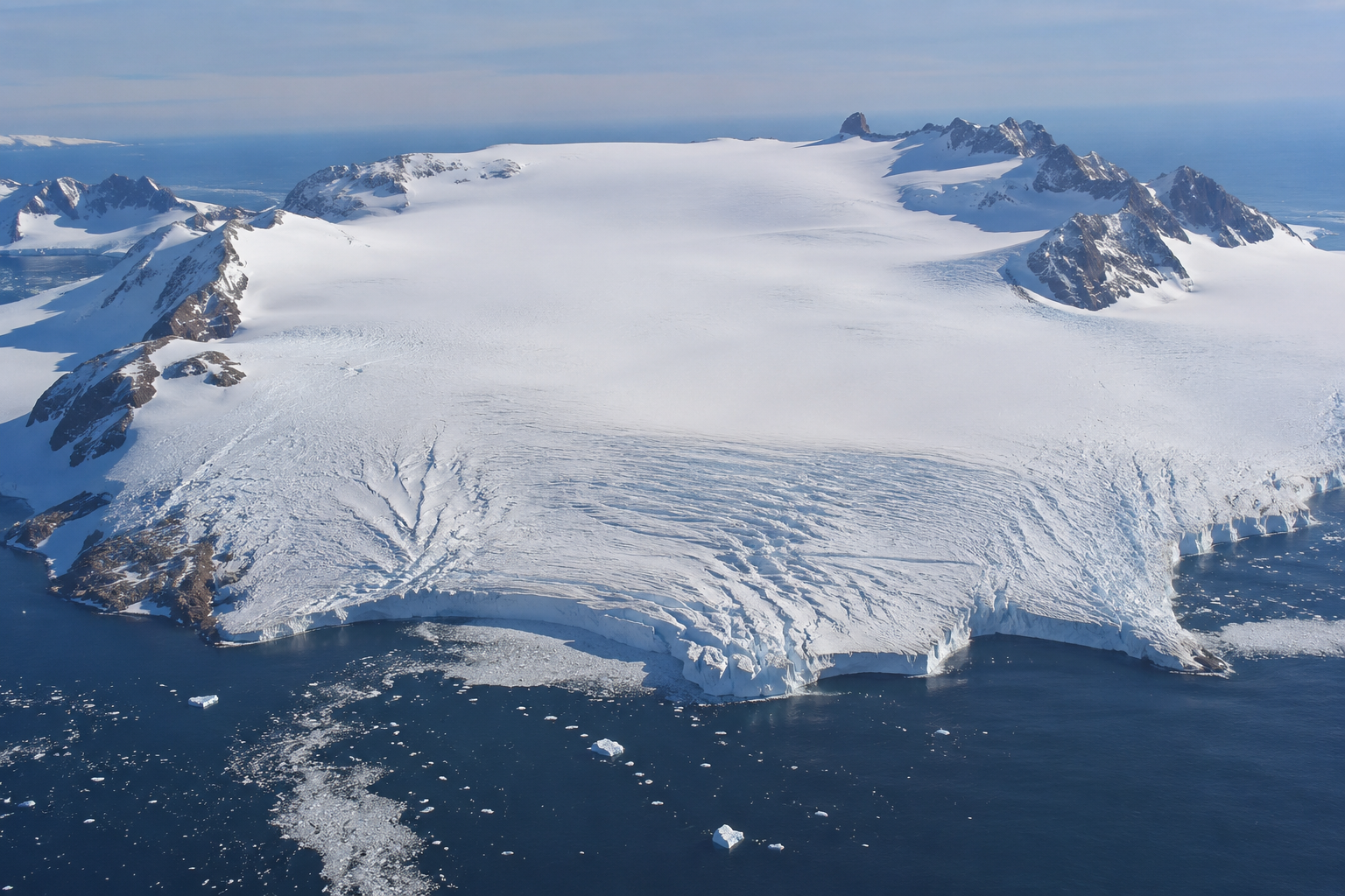 Illustration of an Antarctic ice cap and glacier front meeting dark ocean water, with rocky peaks breaking through the ice